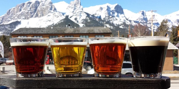 Beer Flight with Rundle Mountain range in the background