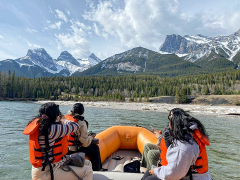 Floating down the Bow River in Canmore, Alberta, guests gaze at the Three Sisters 