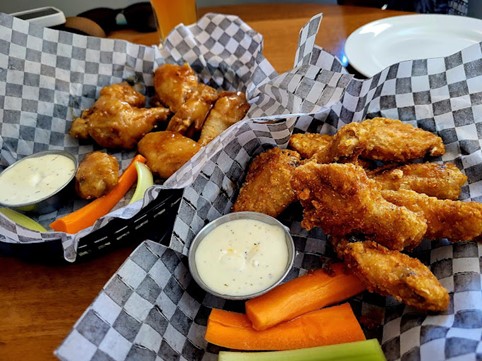 Chicken Wings with a side of Ranch Dip and crisp carrots and celery served at the Mineshaft Tavern in Canmore, AB, their Tuesday dining special