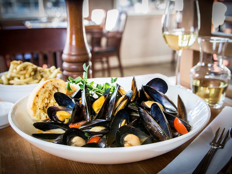 Bowl full of Mussels paired with a glass of white wine found at Table Food + Drink in Canmore, Alberta