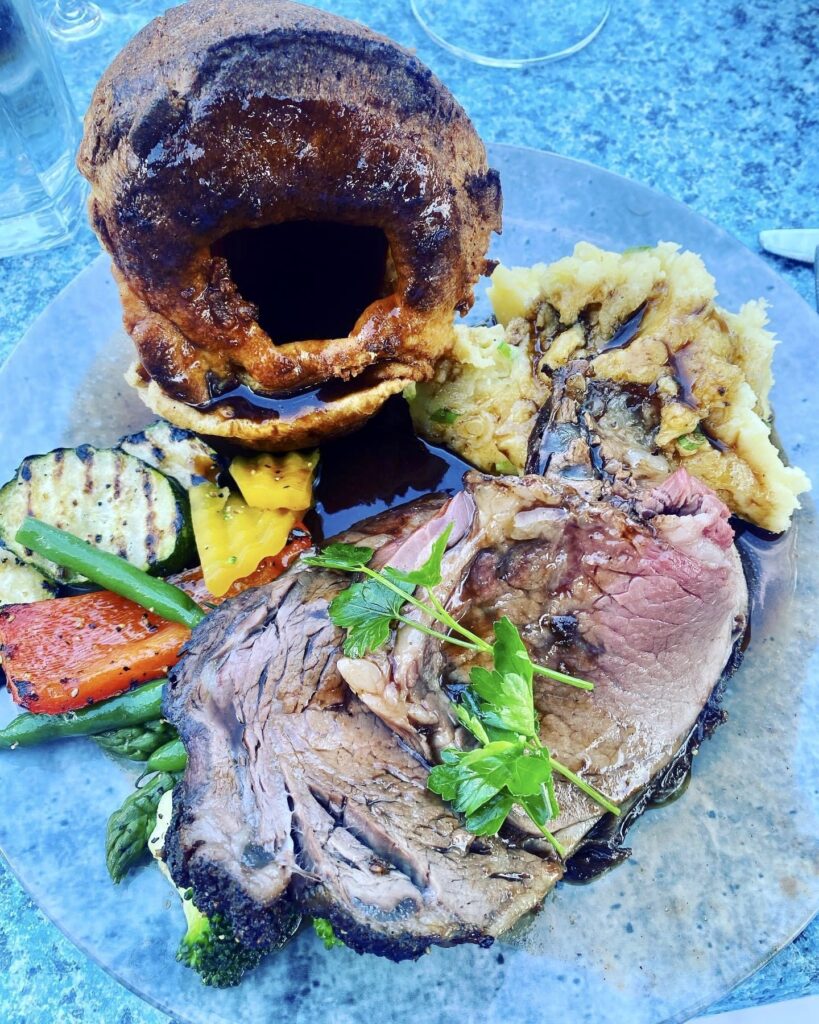 Full plate of a Prime Rib dinner with potatoes and gravy, roasted vegetables and a yorkshire pudding served Fridays in Canmore, Alberta
