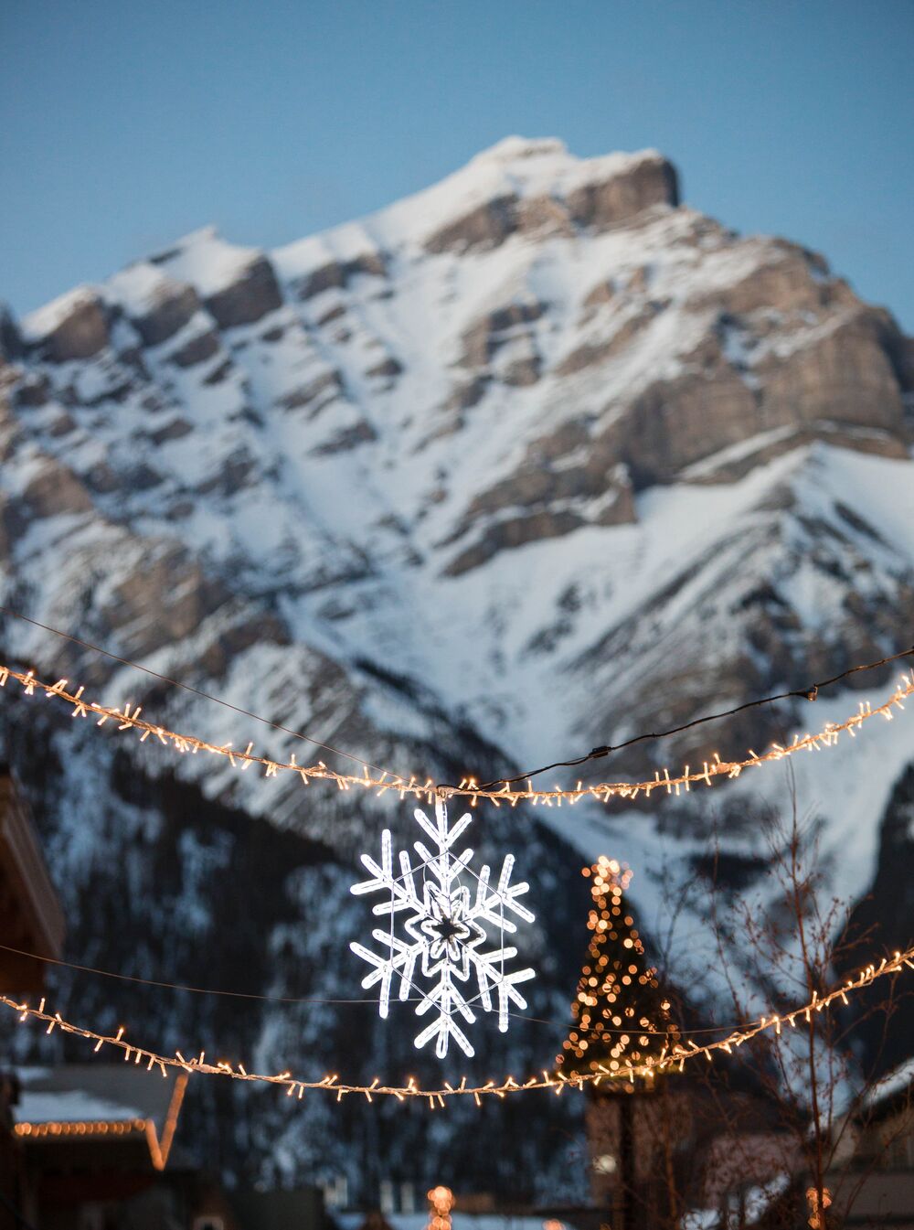 Cascade Mountain in the background of hung lights in the streets of Banff townsite in Banff National Park
