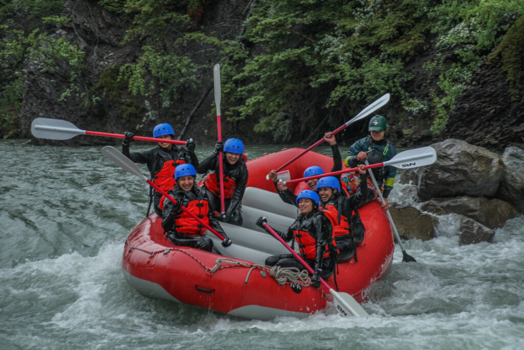 Rafters in full gear - wetsuit, wetsuit jacket, gloves, life jacket and helmets - perfect to raft in the rain with Canadian Rockies Rafting