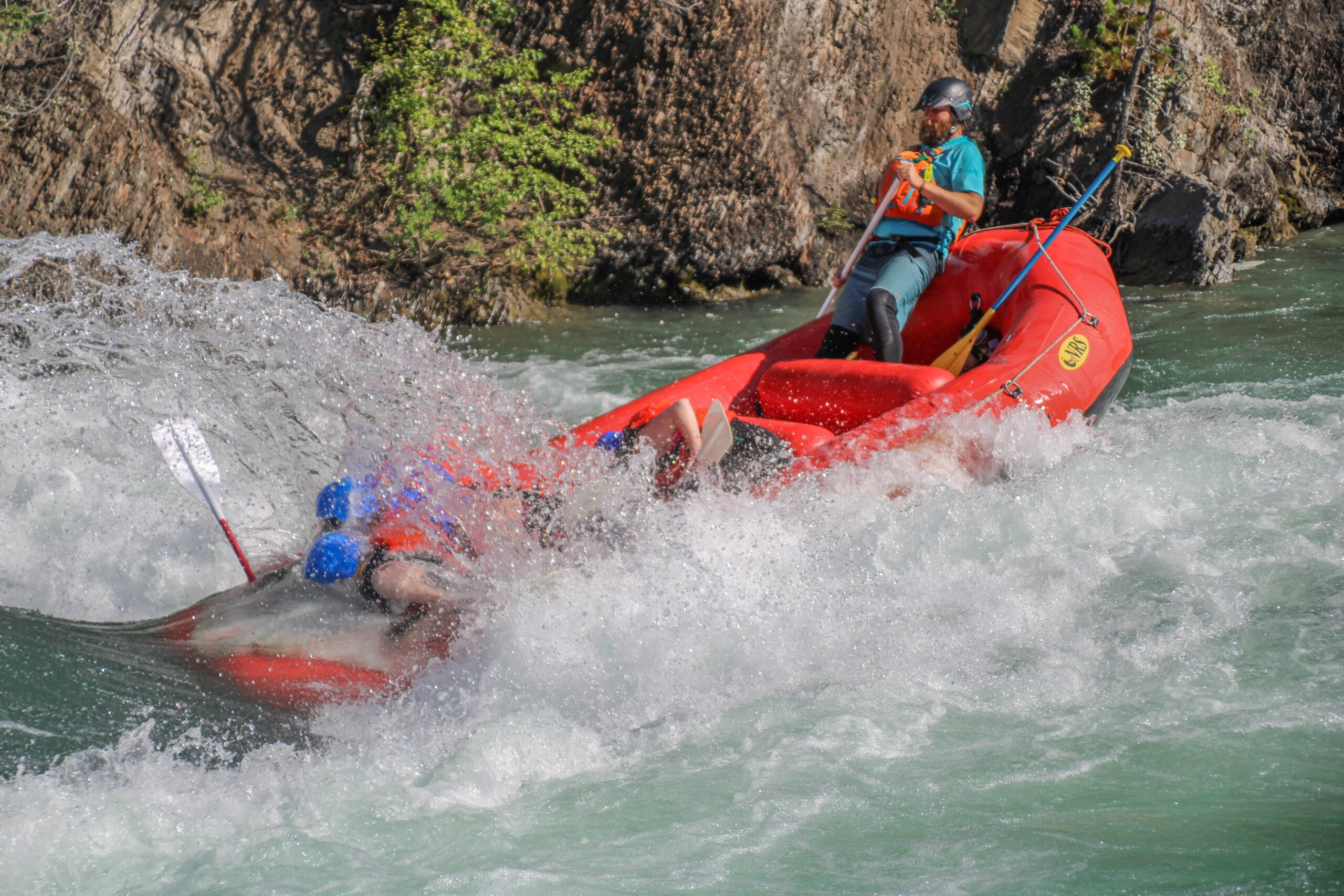 Rafters on the Kananaskis Surf Trip in red raft with Canadian Rockies Rafting in Alberta, Canada